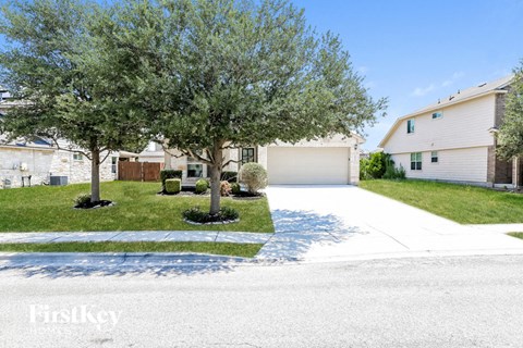 a white house with a driveway and trees