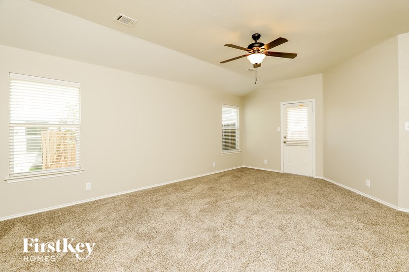 an empty living room with a ceiling fan