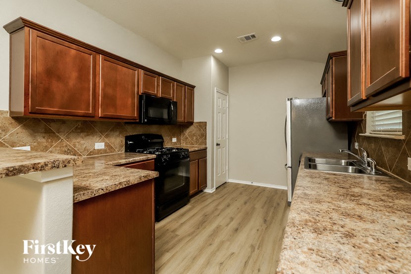a kitchen with wooden cabinets and stainless steel appliances