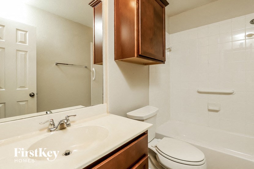 a bathroom with a sink toilet and a mirror