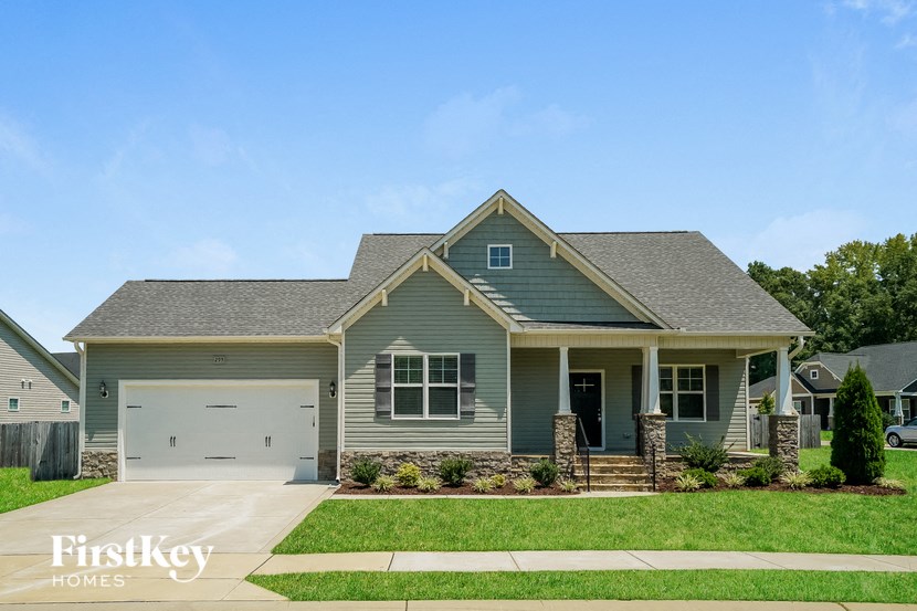 a house with a green exterior and a green lawn