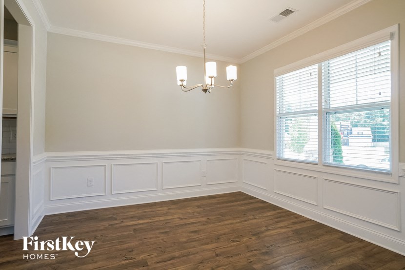 the dining room of a home with wood floors and white walls