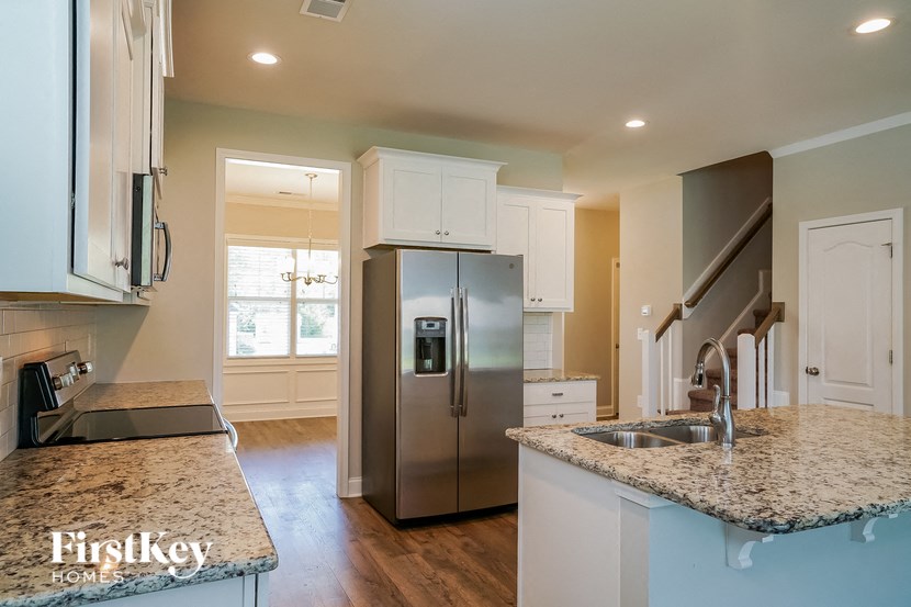 a kitchen with granite counter tops and a stainless steel refrigerator