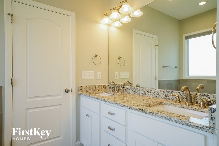 a bathroom with white cabinets and a sink and a mirror
