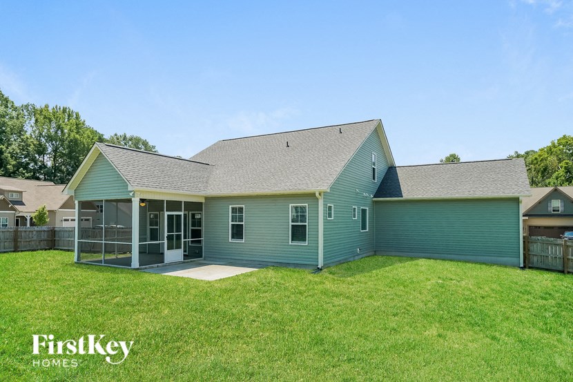 a blue house with a grass yard and a green fence