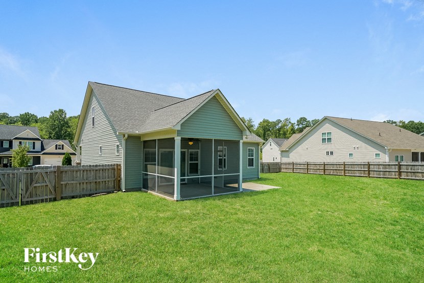 a backyard with a green house and a grass yard
