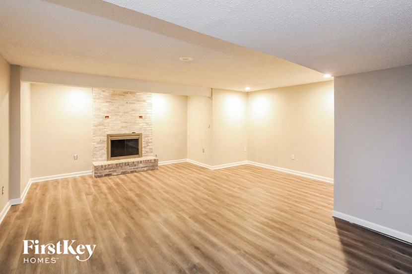 the living room of an empty house with a fireplace