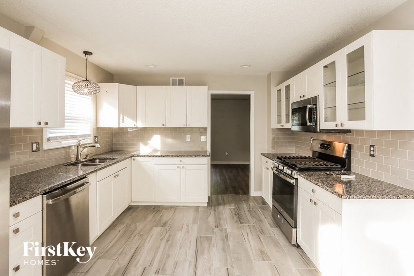 a white kitchen with marble counter tops and white cabinets