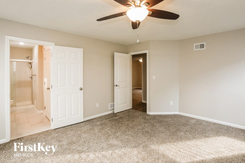 the living room of an empty house with a ceiling fan