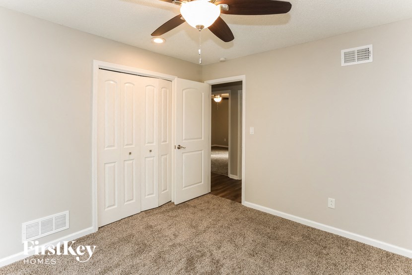 a bedroom with two closets and a ceiling fan