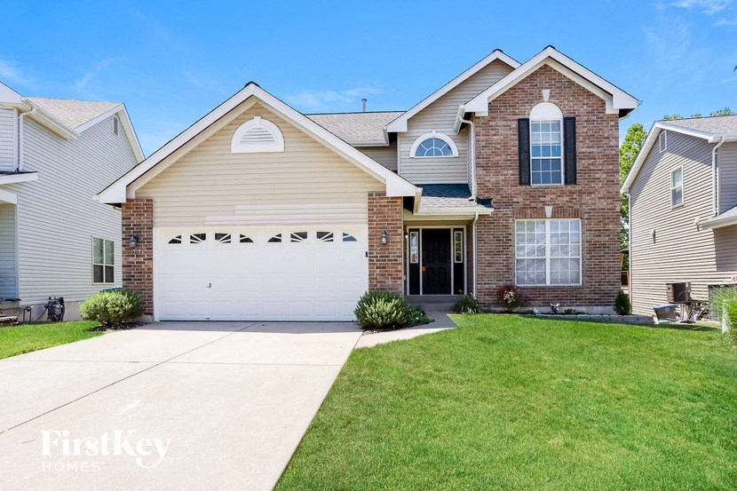 a house with a white garage door and a lawn