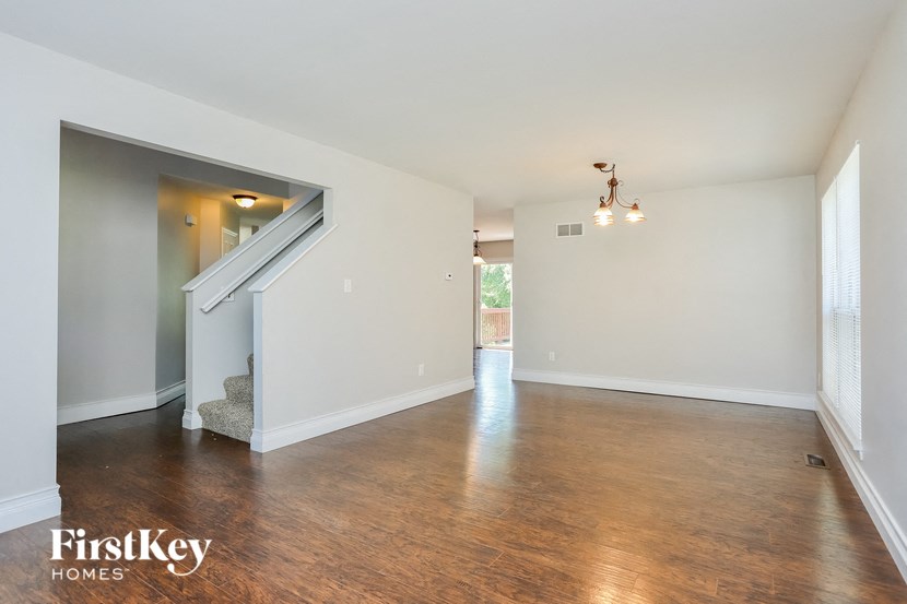 an empty living room with white walls and wood floors