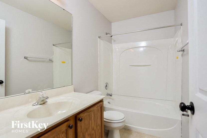 a bathroom with a shower toilet and sink and a mirror