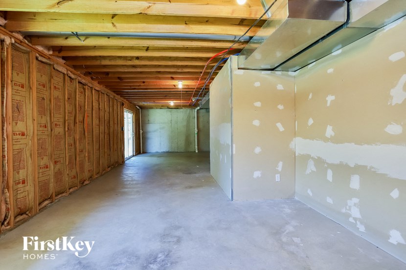 an unfinished basement with plywood walls and a closet