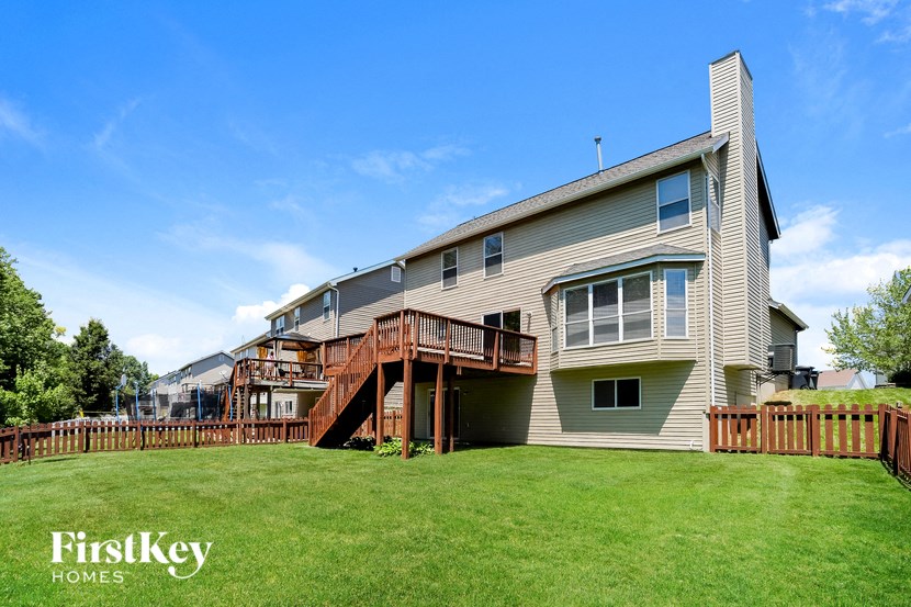 the back of a house with a yard and a deck