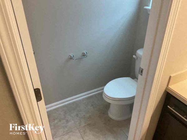 a bathroom with a toilet and a white wall