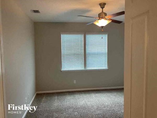an empty room with a ceiling fan and a window