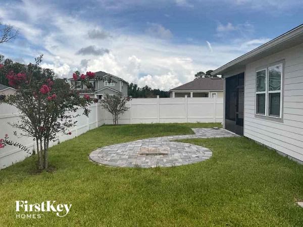a backyard with a patio and a white fence