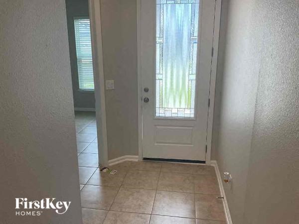 a hallway with a white door and a tiled floor