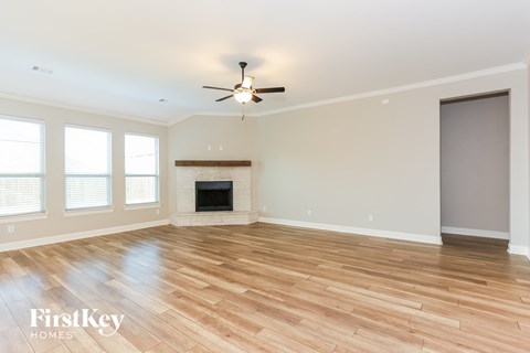 a living room with a fireplace and a ceiling fan