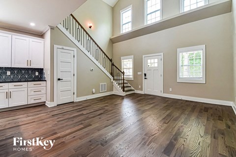 an open living room with white cabinets and a staircase