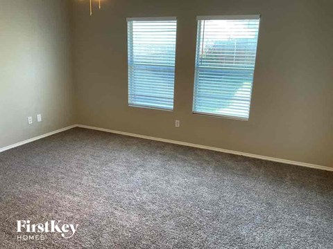 a carpeted room with two windows in it