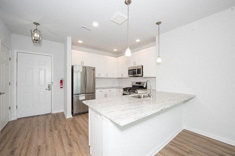 an empty kitchen with a marble counter top