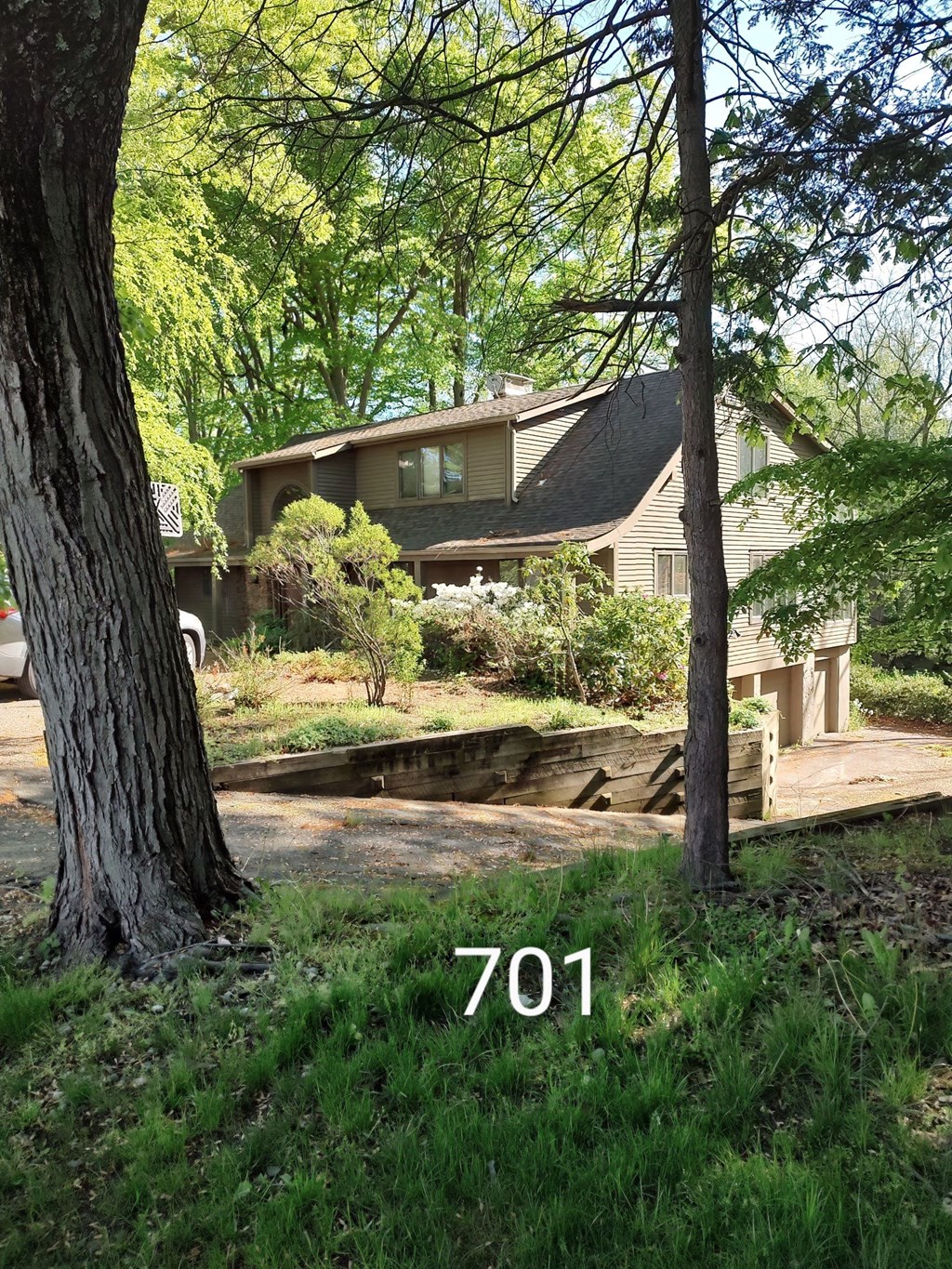 a view of the front of a house with a deck and a tree