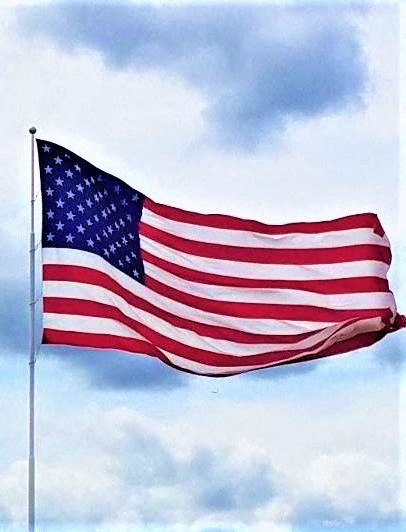 an flag blowing in the wind against a cloudy sky