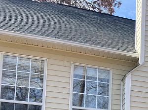 A wooden deck is in front of a house.