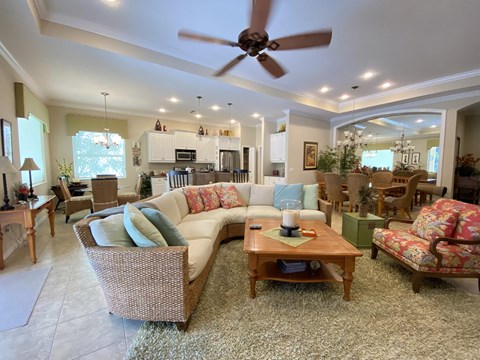 A living room with a white couch and a ceiling fan.