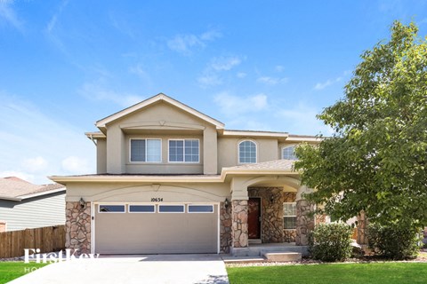 A house with a garage and a driveway in front of it.