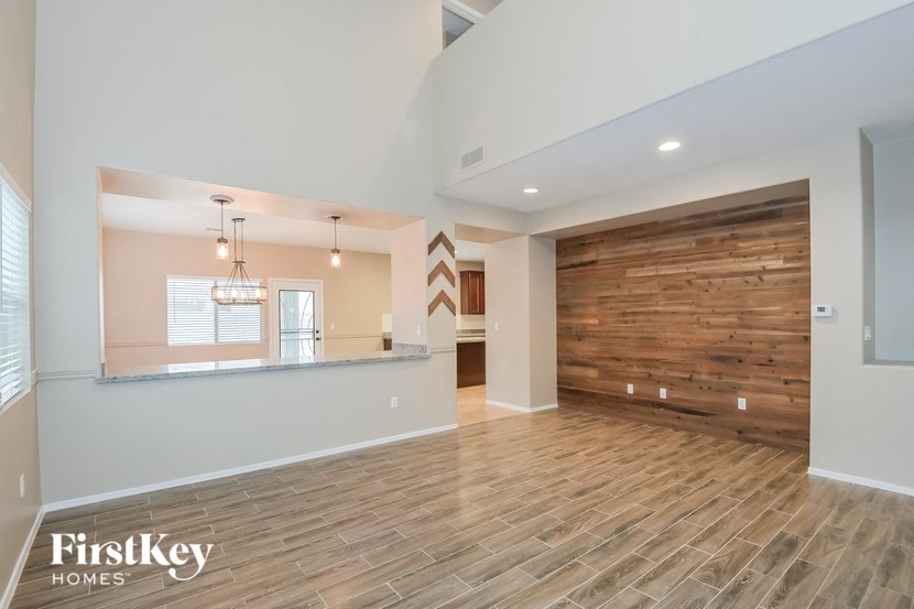 A spacious room with wooden flooring and a wooden wall.