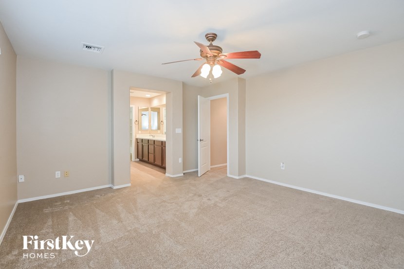 A spacious room with a ceiling fan and a carpeted floor.