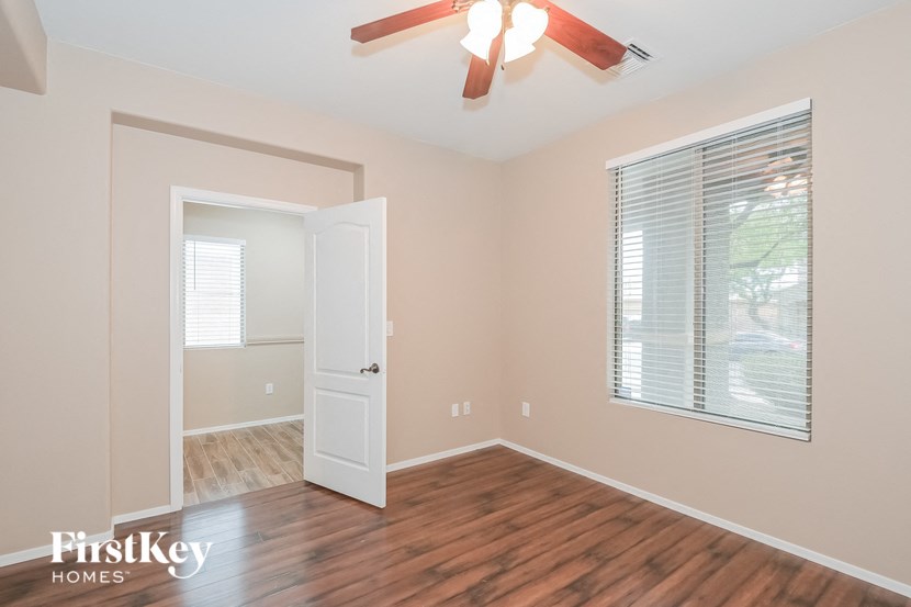 A room with a wooden floor and a ceiling fan.