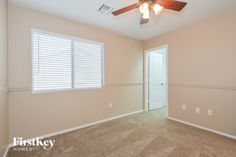 A room with a ceiling fan and a door.