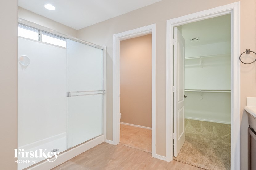 A white door is open to a room with a beige wall.