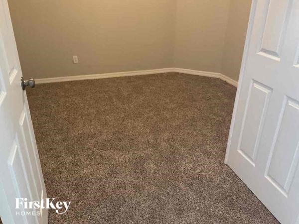 A room with a carpeted floor and a white door.