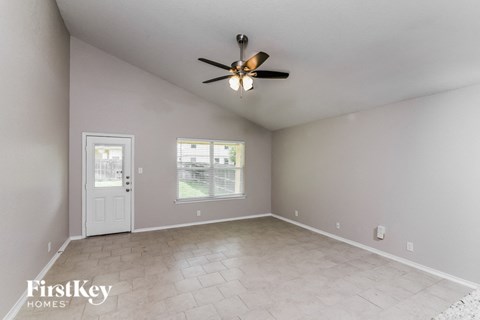 A room with a ceiling fan and a door.