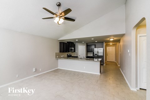 A spacious kitchen with a ceiling fan and a countertop.