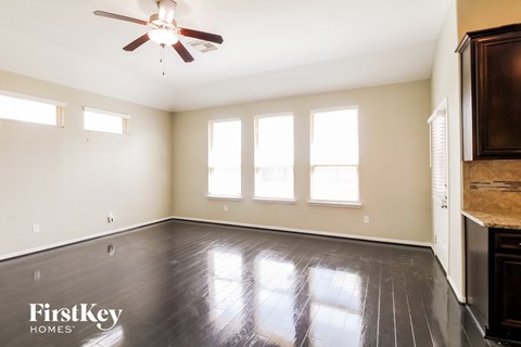 A room with a wooden floor and a ceiling fan.