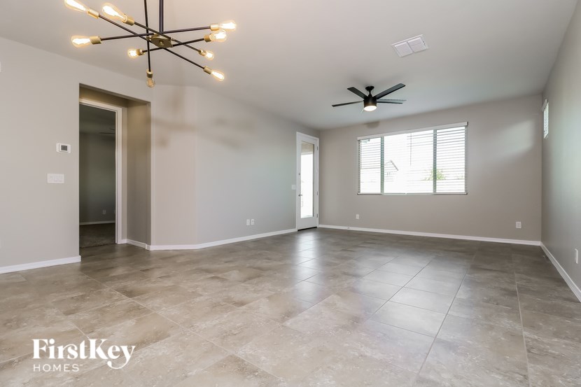 A spacious room with a ceiling fan and a chandelier.