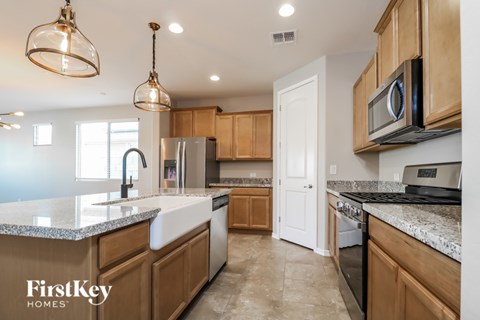 A kitchen with wooden cabinets and a granite countertop.