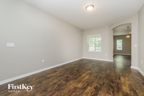 A room with wooden floors and a doorway leading to another room.