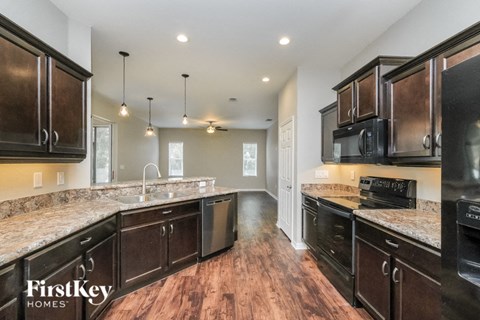A kitchen with dark wood cabinets and granite countertops.