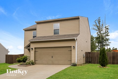 a house with a garage door and a lawn