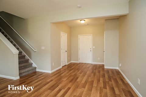 a empty living room with a wooden floor and stairs