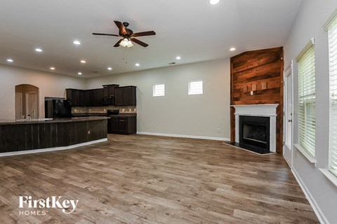 A spacious living room with a fireplace and wood flooring.