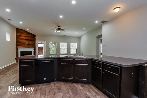 A kitchen with dark wood cabinets and a wooden accent wall.