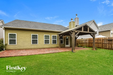 A house with a covered patio and a brick walkway.